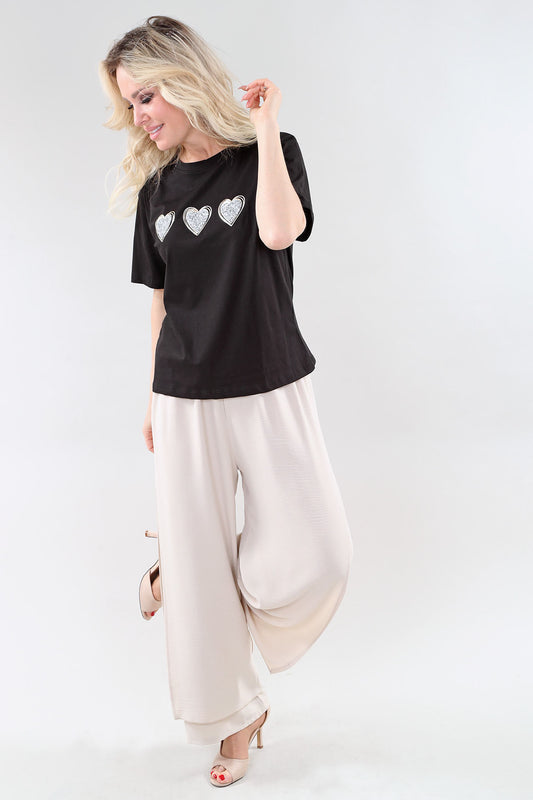 Black women’s printed t-shirt with heart design styled with wide leg pants