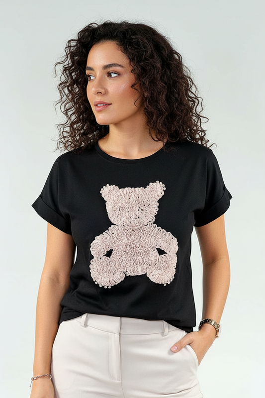 Woman wearing a black t-shirt with a pink teddy bear design on a white background